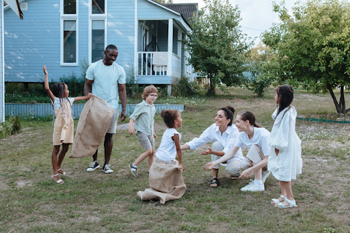 Adults and children enjoying a sack race in a backyard